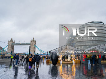 People explore the Christmas market near Tower Bridge and City Hall, in London, United Kingdom, on December 8, 2024 (