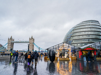 People explore the Christmas market near Tower Bridge and City Hall, in London, United Kingdom, on December 8, 2024 (