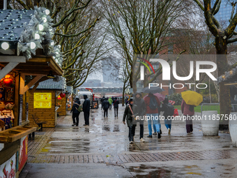 Visitors walk with umbrellas along a wet South Bank during Storm Darragh on December 7, 2024, in London, United Kingdom. London's Royal Park...