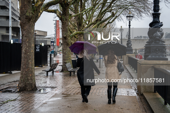 Two women walk under umbrellas along the South Bank during Storm Darragh on December 7, 2024, in London, United Kingdom  London's Royal Park...