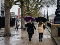 Two women walk under umbrellas along the South Bank during Storm Darragh on December 7, 2024, in London, United Kingdom  London's Royal Park...