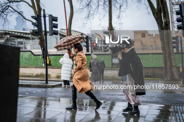 Women struggle with strong winds and rain while crossing a street during Storm Darragh on December 8, 2024, in London, United Kingdom. Londo...