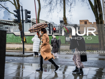 Women struggle with strong winds and rain while crossing a street during Storm Darragh on December 8, 2024, in London, United Kingdom. Londo...