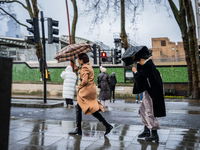 Women struggle with strong winds and rain while crossing a street during Storm Darragh on December 8, 2024, in London, United Kingdom. Londo...