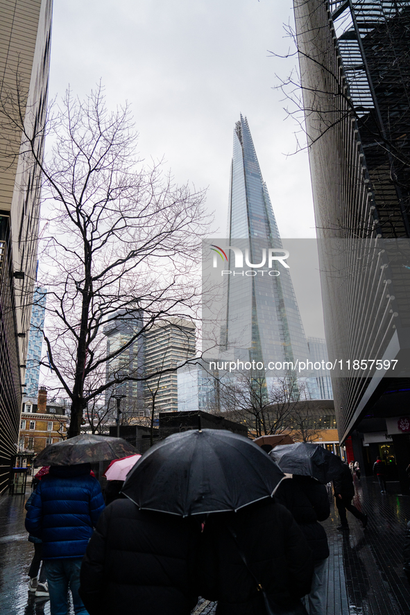 An umbrella shields a person from rain while standing near The Shard during Storm Darragh on December 8, 2024, in London, United Kingdom. Lo...