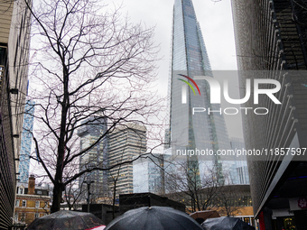 An umbrella shields a person from rain while standing near The Shard during Storm Darragh on December 8, 2024, in London, United Kingdom. Lo...