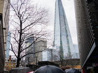 An umbrella shields a person from rain while standing near The Shard during Storm Darragh on December 8, 2024, in London, United Kingdom. Lo...