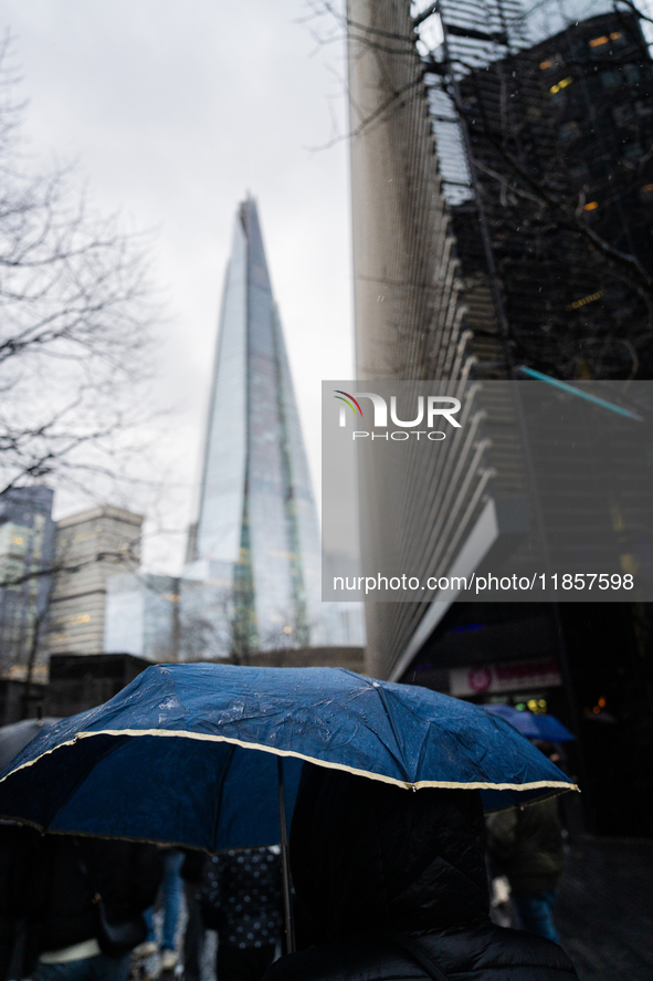 An umbrella shields a person from rain while standing near The Shard during Storm Darragh on December 8, 2024, in London, United Kingdom. Lo...