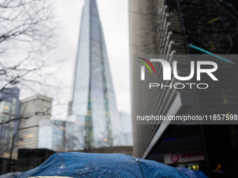 An umbrella shields a person from rain while standing near The Shard during Storm Darragh on December 8, 2024, in London, United Kingdom. Lo...