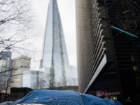 An umbrella shields a person from rain while standing near The Shard during Storm Darragh on December 8, 2024, in London, United Kingdom. Lo...