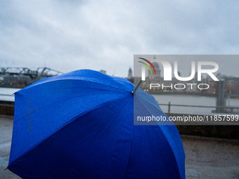 A blue umbrella provides cover during a rainy day with St. Paul's Cathedral in the background as Storm Darragh impacts London on December 8,...