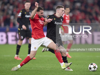 Orkun Kokcu of SL Benfica competes for the ball with Lewis Ferguson of Bologna Football Club 1909 during the UEFA Champions League match bet...