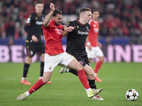 Orkun Kokcu of SL Benfica competes for the ball with Lewis Ferguson of Bologna Football Club 1909 during the UEFA Champions League match bet...