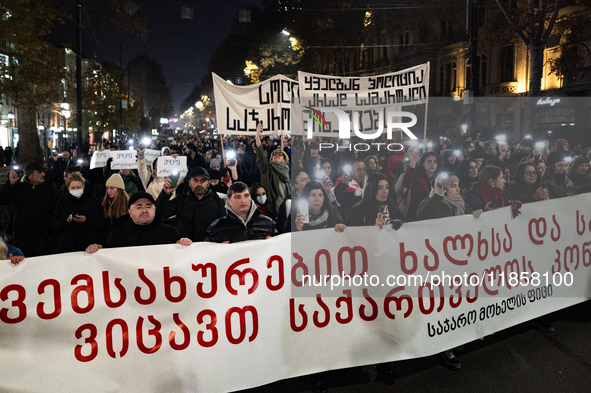 Georgia pro-Europe demonstrators stand behind a banner during a protest against the government's postponement of European Union accession ta...