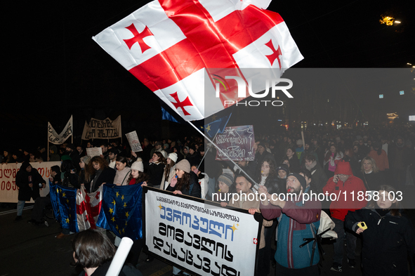 Georgia pro-Europe demonstrators hold the Georgian flag during a protest against the government's postponement of European Union accession t...