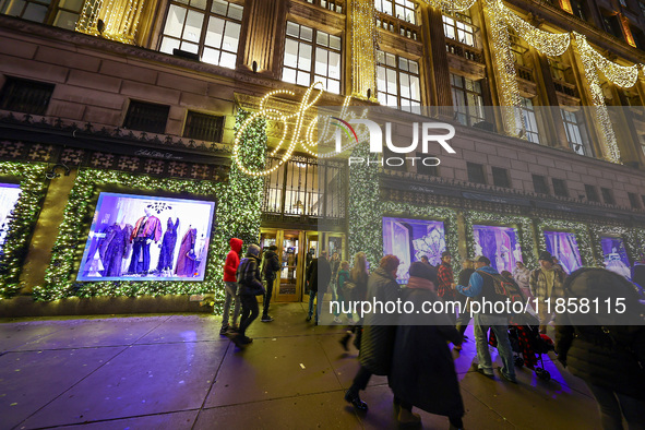 People walk past the entrance of Saks Fifth Avenue in New York, N.Y., on December 10, 2024. 