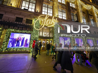 People walk past the entrance of Saks Fifth Avenue in New York, N.Y., on December 10, 2024. (