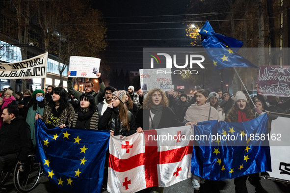 Georgia pro-Europe demonstrators hold Georgian and European flags during a protest against the Government's postponement of European Union a...