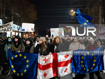 Georgia pro-Europe demonstrators hold Georgian and European flags during a protest against the Government's postponement of European Union a...