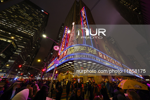 The Christmas tree made of lights stands on the marquee of Radio City Music Hall with the Rockefeller Center illuminated in the background i...