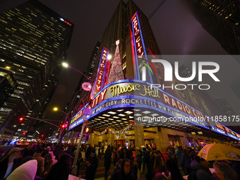 The Christmas tree made of lights stands on the marquee of Radio City Music Hall with the Rockefeller Center illuminated in the background i...