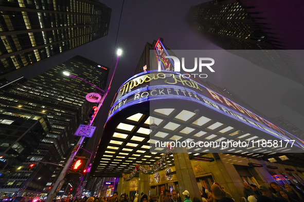 The Christmas tree made of lights stands on the marquee of Radio City Music Hall with the Rockefeller Center illuminated in the background i...