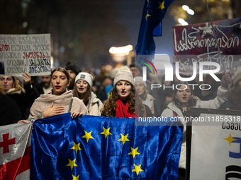 Georgia pro-Europe demonstrators hold Georgian and European flags during a protest against the Government's postponement of European Union a...