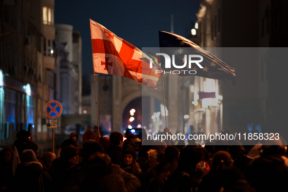 Georgia pro-Europe demonstrators hold Georgian and European flags during a protest against the Government's postponement of European Union a...