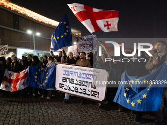 Georgia pro-Europe demonstrators hold Georgian and European flags during a protest against the Government's postponement of European Union a...