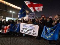 Georgia pro-Europe demonstrators hold Georgian and European flags during a protest against the Government's postponement of European Union a...