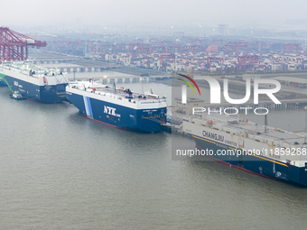 Cars are loaded and unloaded at a ro-ro vehicle terminal for export at Taicang Port area in Suzhou, East China's Jiangsu province, on Decemb...