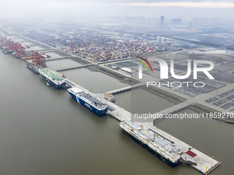 Cars are loaded and unloaded at a ro-ro vehicle terminal for export at Taicang Port area in Suzhou, East China's Jiangsu province, on Decemb...