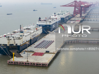 Cars are loaded and unloaded at a ro-ro vehicle terminal for export at Taicang Port area in Suzhou, East China's Jiangsu province, on Decemb...