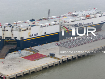 Cars are loaded and unloaded at a ro-ro vehicle terminal for export at Taicang Port area in Suzhou, East China's Jiangsu province, on Decemb...