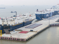 Cars are loaded and unloaded at a ro-ro vehicle terminal for export at Taicang Port area in Suzhou, East China's Jiangsu province, on Decemb...