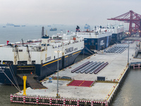 Cars are loaded and unloaded at a ro-ro vehicle terminal for export at Taicang Port area in Suzhou, East China's Jiangsu province, on Decemb...