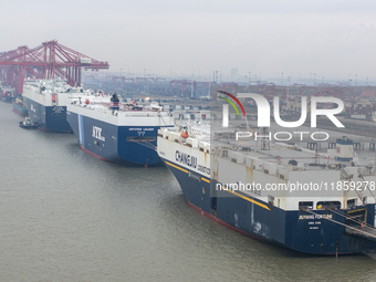 Cars are loaded and unloaded at a ro-ro vehicle terminal for export at Taicang Port area in Suzhou, East China's Jiangsu province, on Decemb...