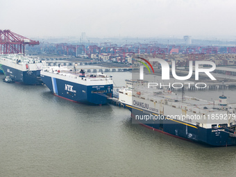 Cars are loaded and unloaded at a ro-ro vehicle terminal for export at Taicang Port area in Suzhou, East China's Jiangsu province, on Decemb...