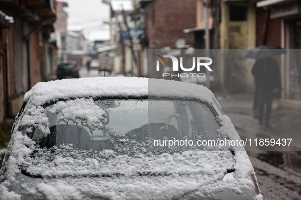 People walk while holding umbrellas during snowfall in Sopore, Jammu and Kashmir, India, on December 12, 2024. 