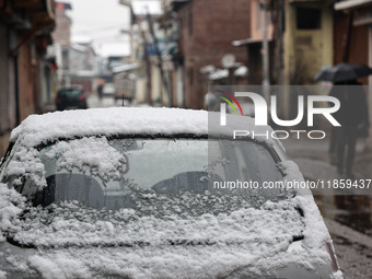 People walk while holding umbrellas during snowfall in Sopore, Jammu and Kashmir, India, on December 12, 2024. (