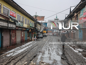 People walk while holding umbrellas during snowfall in Sopore, Jammu and Kashmir, India, on December 12, 2024. (