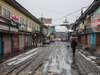 People walk while holding umbrellas during snowfall in Sopore, Jammu and Kashmir, India, on December 12, 2024. (