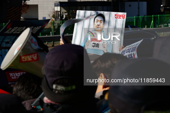 Protesters hold portraits of President Yoon Suk-yeol with the phrase ''Arrest Yoon Suk-yeol, the Rebellion Leader'' written on them as they...