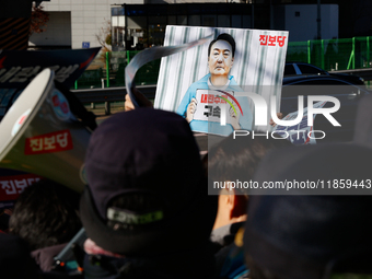 Protesters hold portraits of President Yoon Suk-yeol with the phrase ''Arrest Yoon Suk-yeol, the Rebellion Leader'' written on them as they...