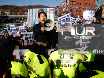 Protesters hold portraits of President Yoon Suk-yeol with the phrase ''Arrest Yoon Suk-yeol, the Rebellion Leader'' written on them as they...