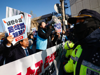 Protesters hold portraits of President Yoon Suk-yeol with the phrase ''Arrest Yoon Suk-yeol, the Rebellion Leader'' written on them as they...