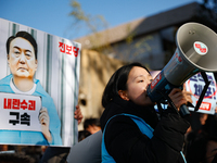 Protesters hold portraits of President Yoon Suk-yeol with the phrase ''Arrest Yoon Suk-yeol, the Rebellion Leader'' written on them as they...