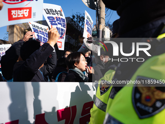 Protesters hold portraits of President Yoon Suk-yeol with the phrase ''Arrest Yoon Suk-yeol, the Rebellion Leader'' written on them as they...