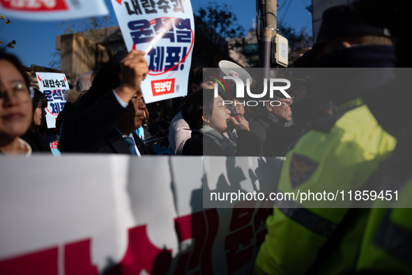 Protesters hold portraits of President Yoon Suk-yeol with the phrase ''Arrest Yoon Suk-yeol, the Rebellion Leader'' written on them as they...