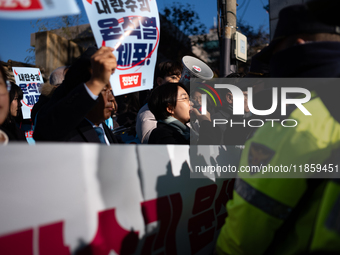 Protesters hold portraits of President Yoon Suk-yeol with the phrase ''Arrest Yoon Suk-yeol, the Rebellion Leader'' written on them as they...